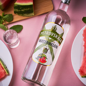 Petrovskaia Watermeloen Vodka 1 liter fles liggend met stukjes watermeloen, munt en een shotglaasje in beeld, hoogwaardige frisse watermeloenwodka