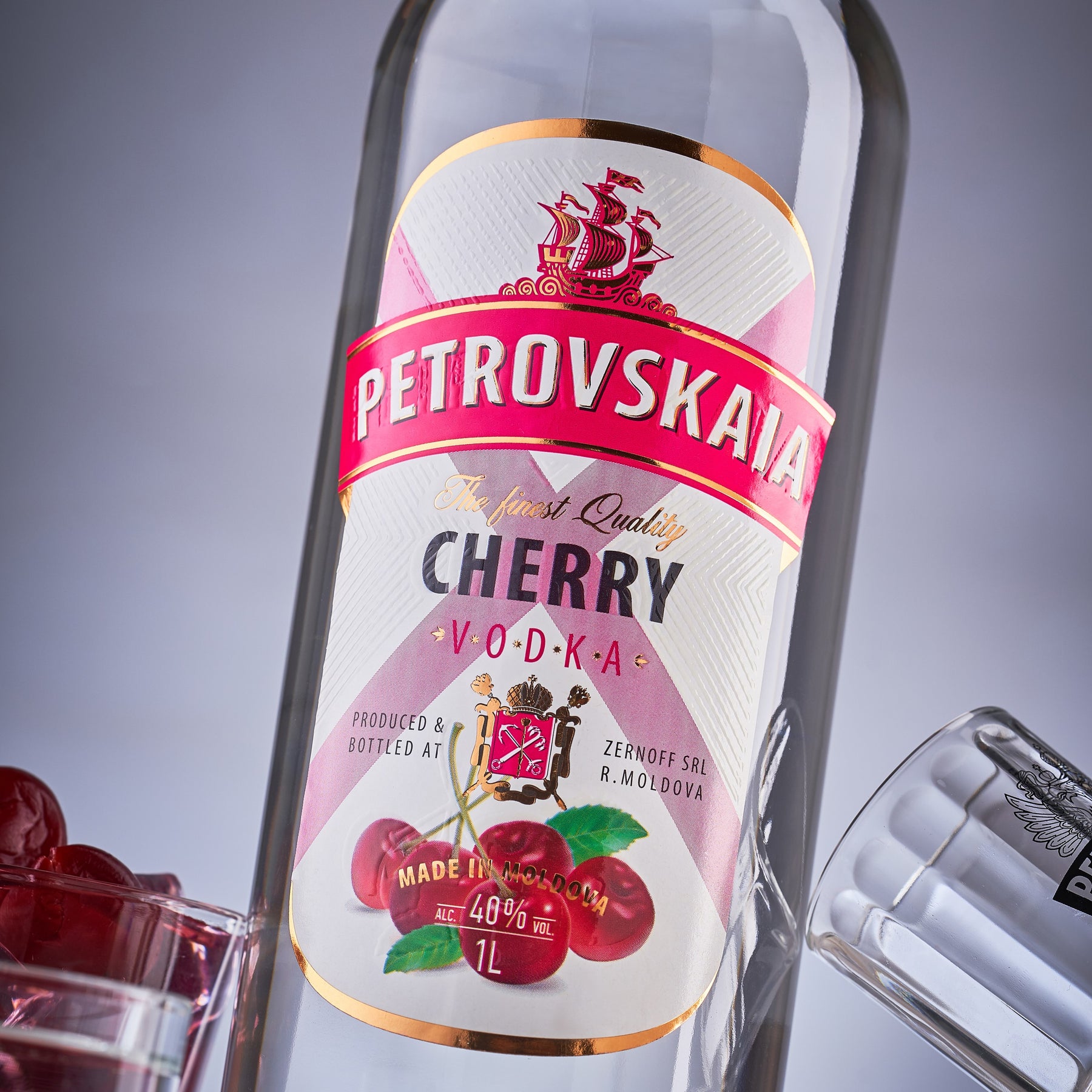 Close-up van de fles Petrovskaia Cherry Premium Vodka 1 liter fles  met kersen en cocktails